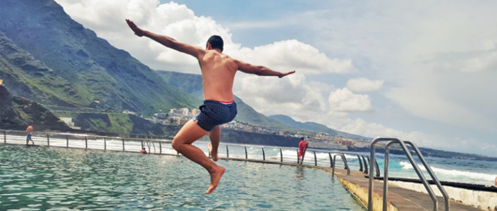 Jumping in a natural pool by the Atlantic